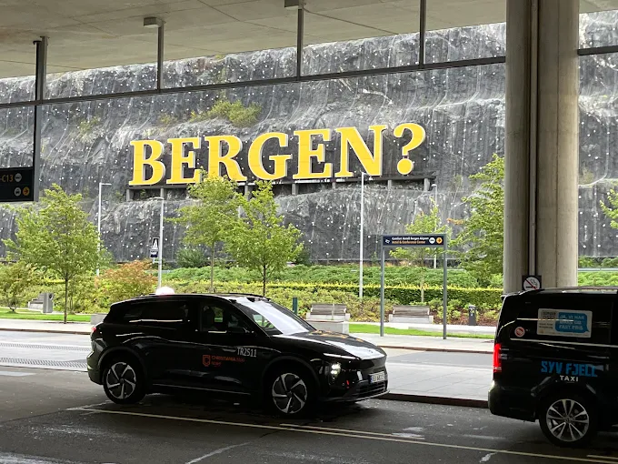 Taxis in front of the Bergen sign at Bergen Airport
