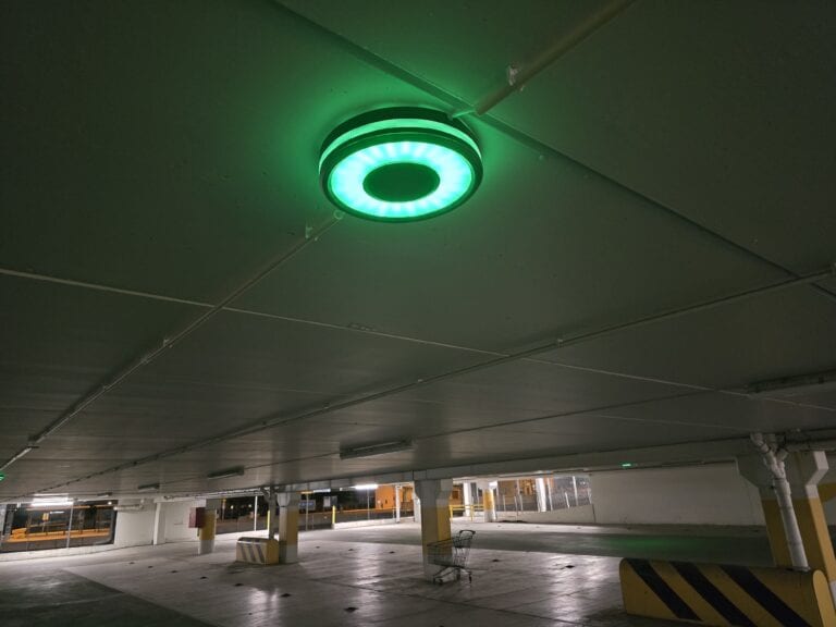 Sensade LED ceiling parking lamp lit green in a car park