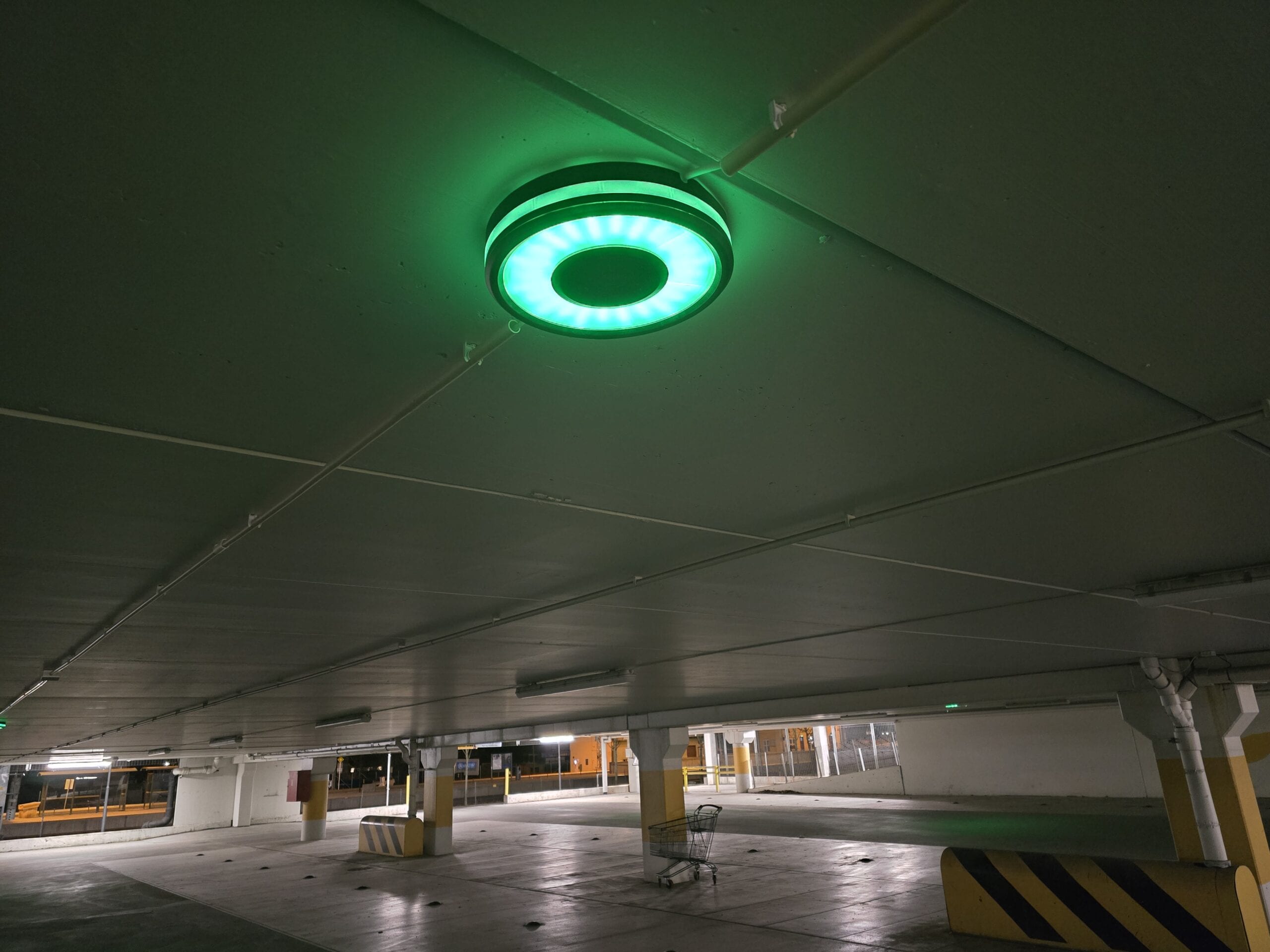 Sensade LED ceiling parking lamp lit green in a car park