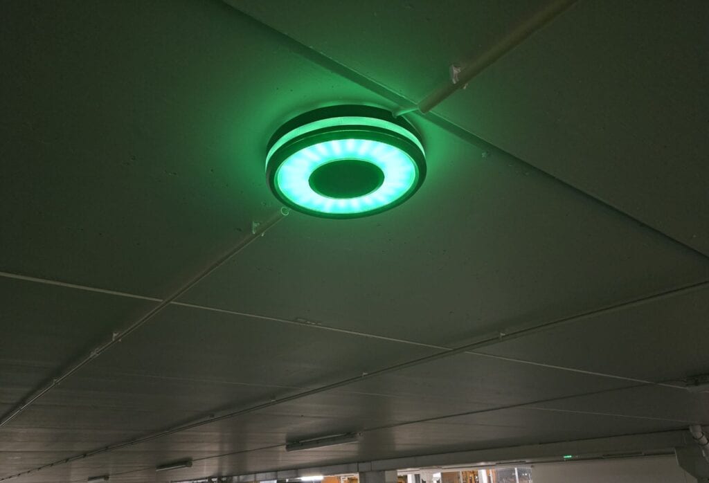 Sensade LED ceiling parking lamp lit green in a car park