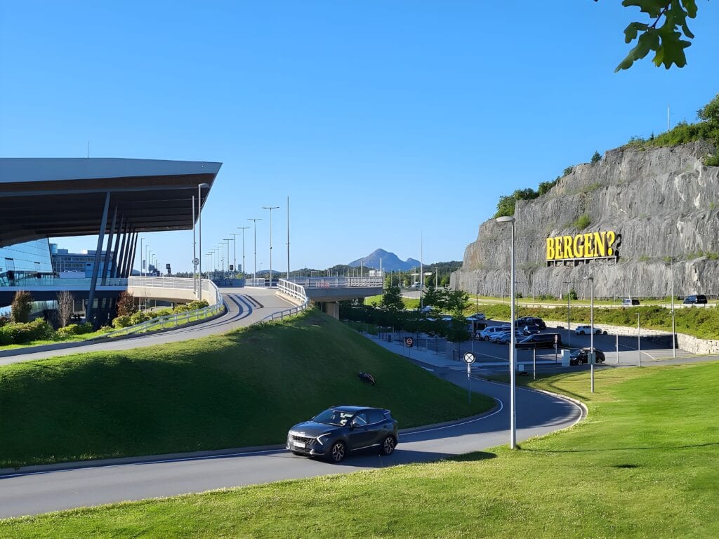 Road leading to Bergen Airport with the Bergen sign on the rock face